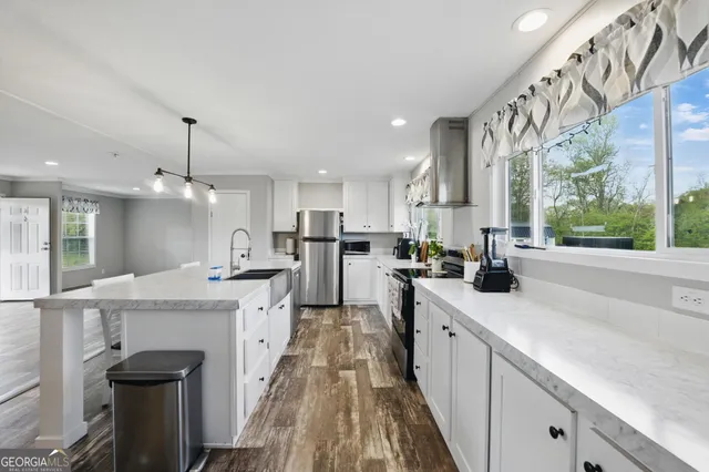 a large kitchen with stainless steel appliances kitchen island granite countertop a sink and cabinets