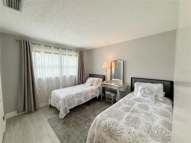 a bedroom with two beds and large window