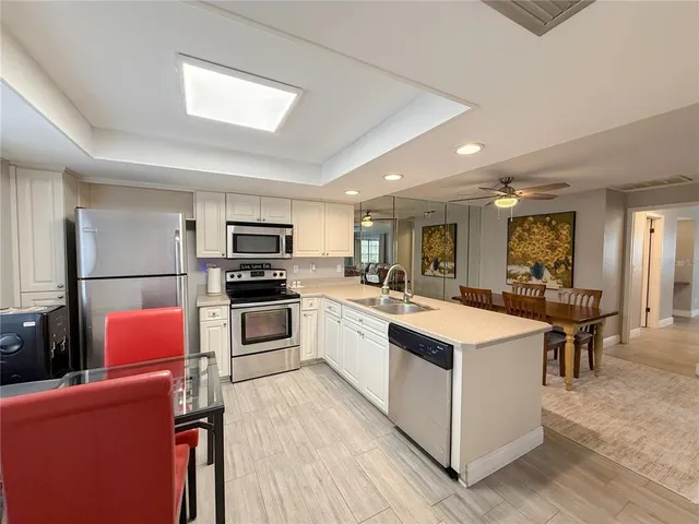 a kitchen with white cabinets and stainless steel appliances
