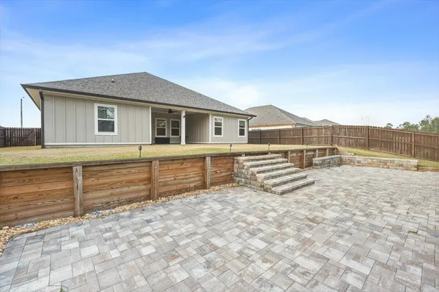 a view of a house with a yard and wooden fence