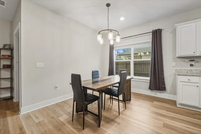 a view of a dining room with furniture wooden floor and chandelier