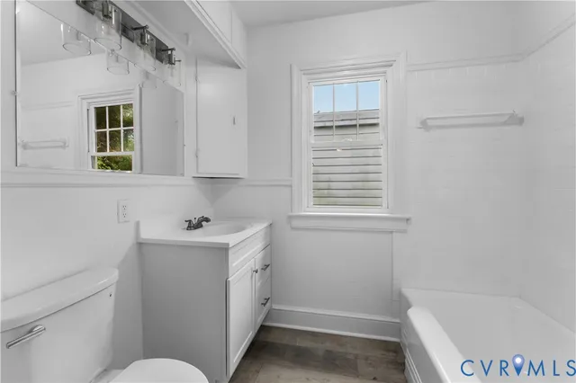 a bathroom with a bathtub sink and mirror