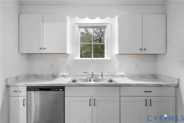 a kitchen with granite countertop white cabinets and a window