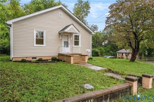 a front view of a house with a yard and trees