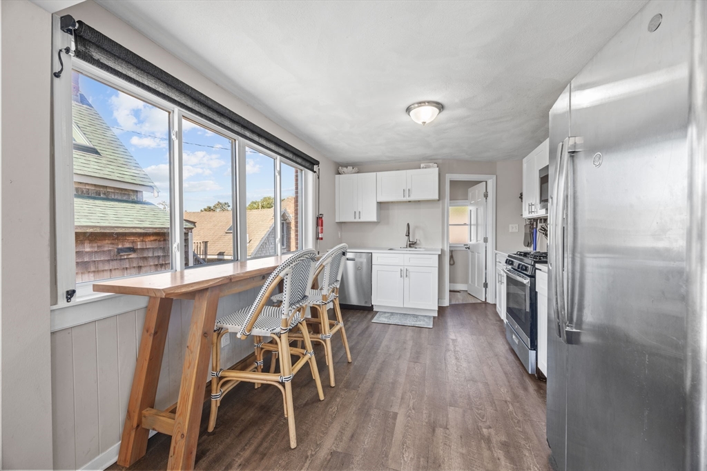 17 5th Street Wareham, MA 02558 - Photo 12 of 32 a kitchen with a table chairs refrigerator and cabinets