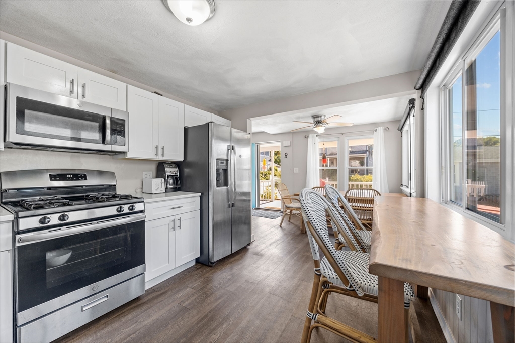 17 5th Street Wareham, MA 02558 - Photo 13 of 32 a kitchen with stainless steel appliances a stove a refrigerator a kitchen island a table and chairs
