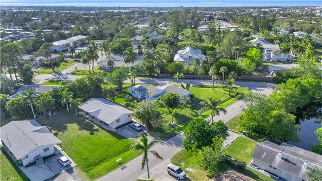 an aerial view of residential houses with outdoor space and trees