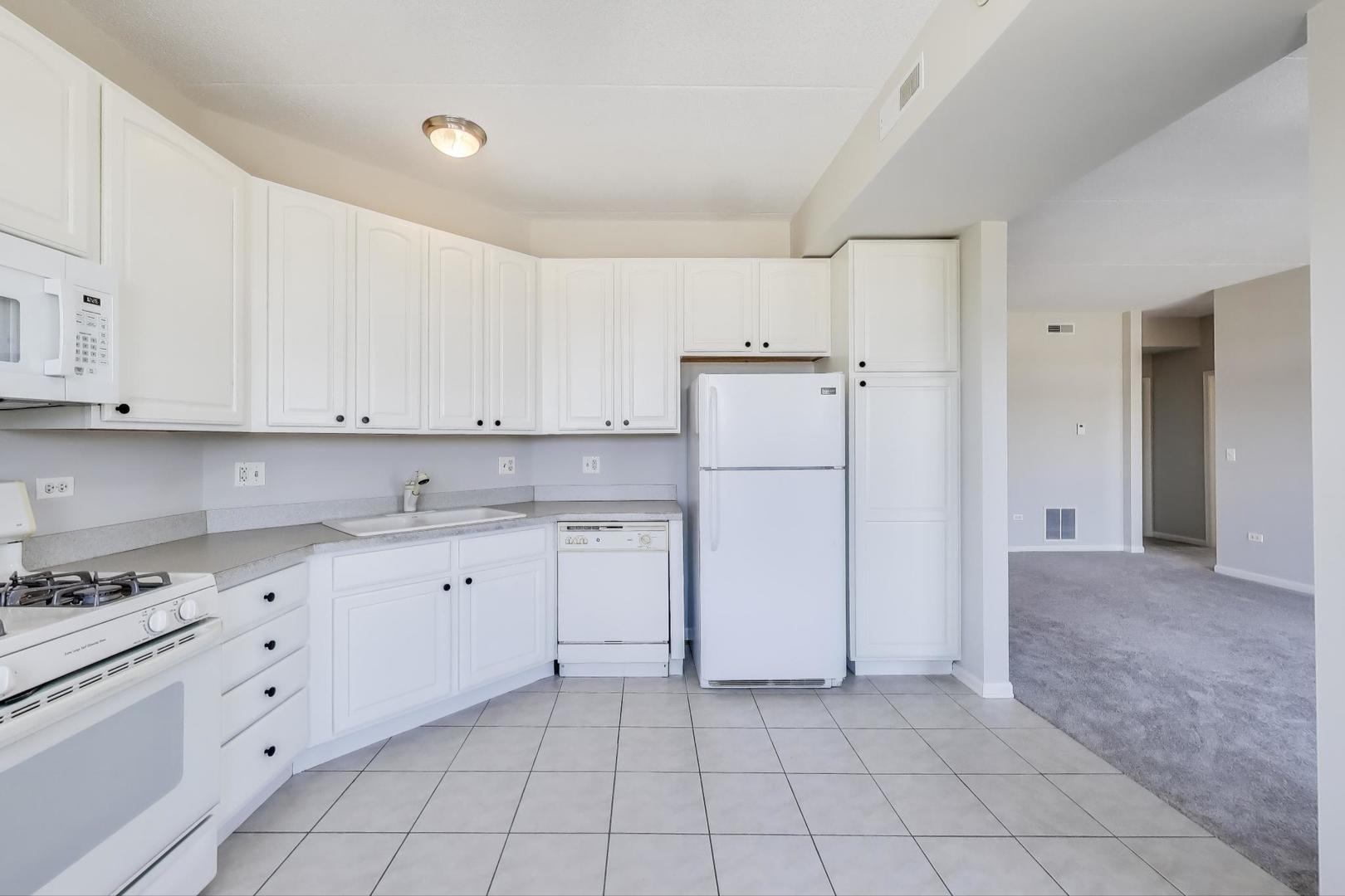 715 Astor Lane, Unit 307 Wheeling, IL 60090 - Photo 11 of 38 a kitchen with white cabinets and white appliances
