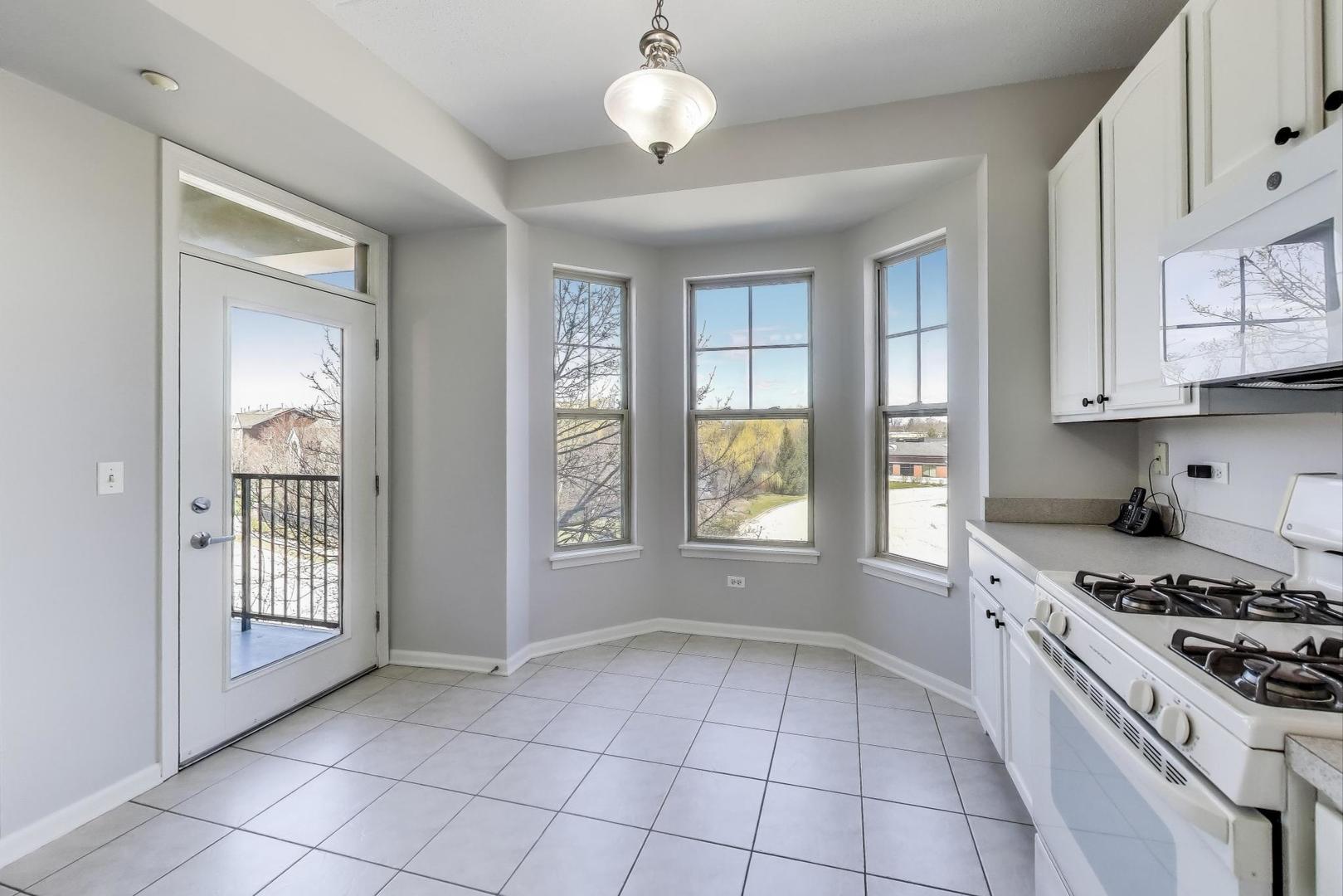 715 Astor Lane, Unit 307 Wheeling, IL 60090 - Photo 13 of 38 a kitchen with granite countertop a stove a sink and a window