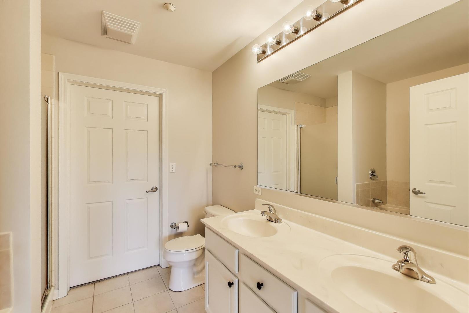 715 Astor Lane, Unit 307 Wheeling, IL 60090 - Photo 19 of 38 a bathroom with a toilet a sink a mirror and vanity