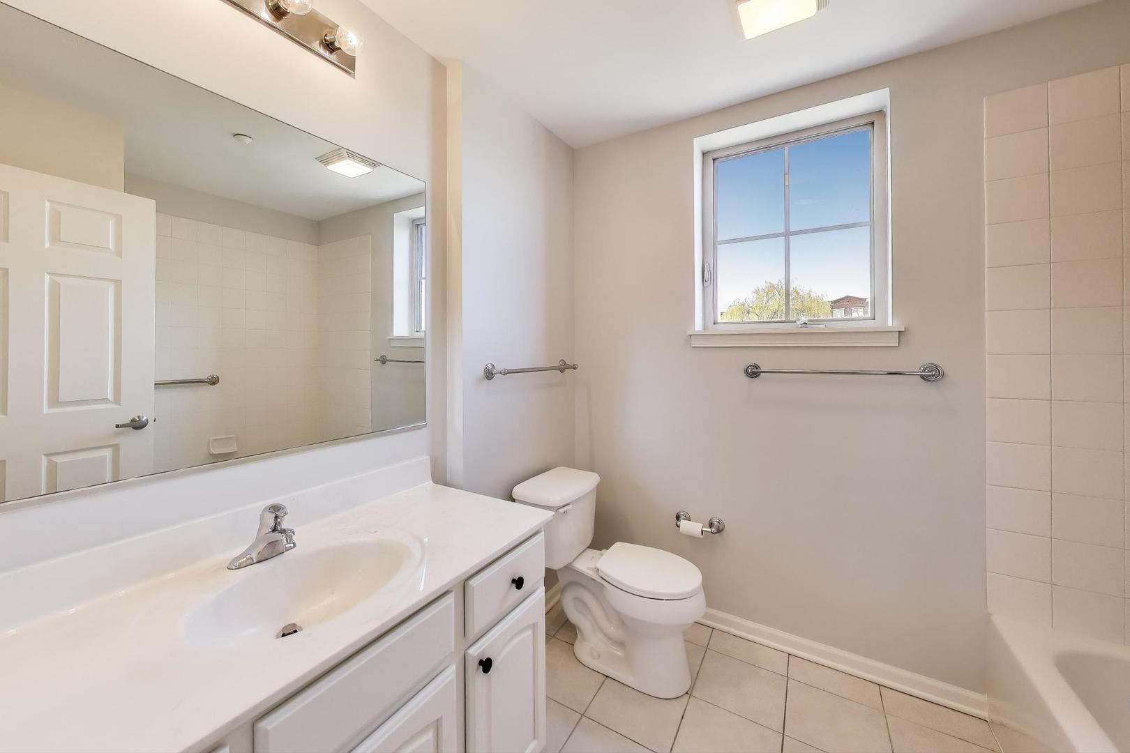 715 Astor Lane, Unit 307 Wheeling, IL 60090 - Photo 23 of 38 a bathroom with a sink a toilet and a mirror