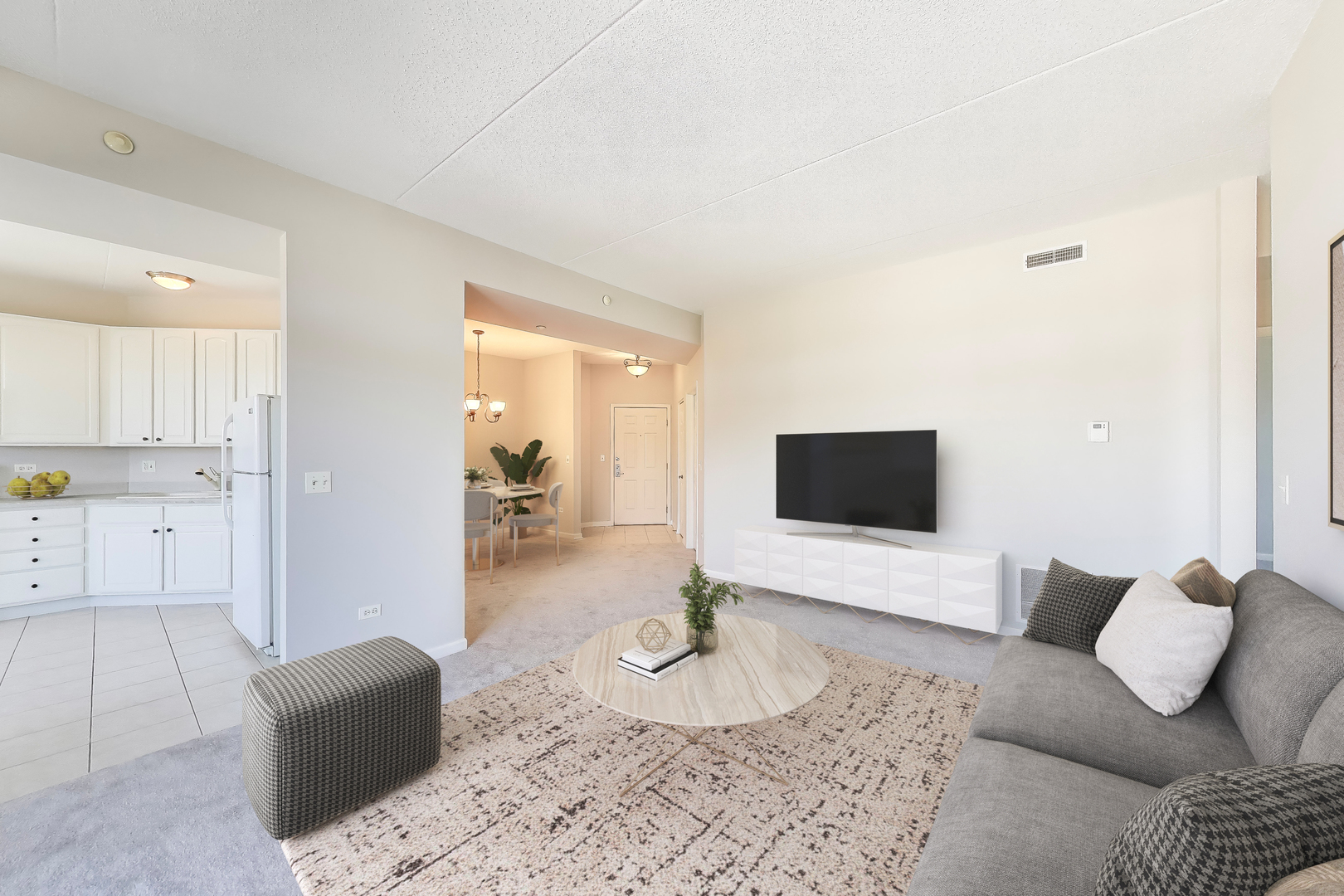 715 Astor Lane, Unit 307 Wheeling, IL 60090 - Photo 4 of 38 a living room with furniture and a flat screen tv