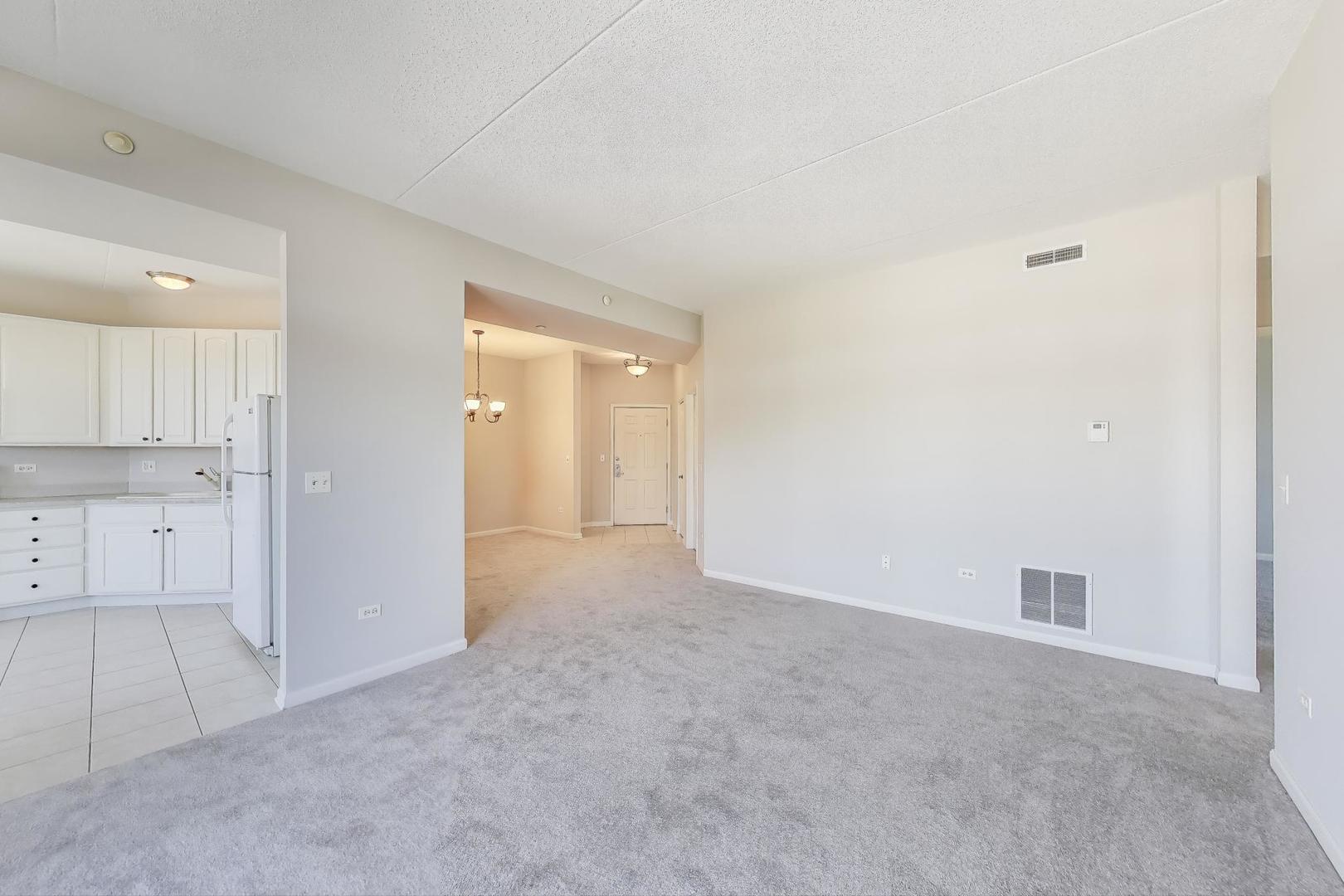 715 Astor Lane, Unit 307 Wheeling, IL 60090 - Photo 5 of 38 a view of an empty room and kitchen view