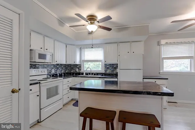 a kitchen with stainless steel appliances granite countertop a white cabinets granite counter tops and a refrigerator