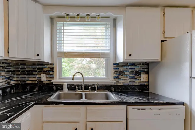 a kitchen with granite countertop a sink cabinets and window