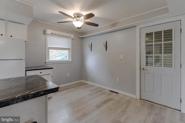 an empty room with windows and ceiling fan