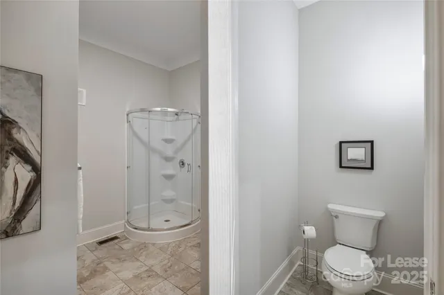 a bathroom with a granite countertop toilet and a shower
