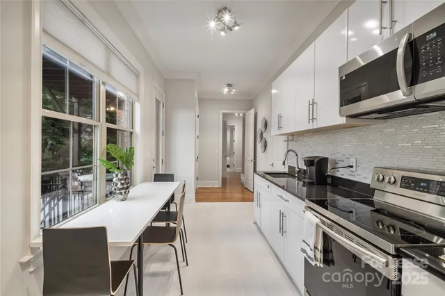 a kitchen with stainless steel appliances kitchen island granite countertop a stove a sink and a microwave