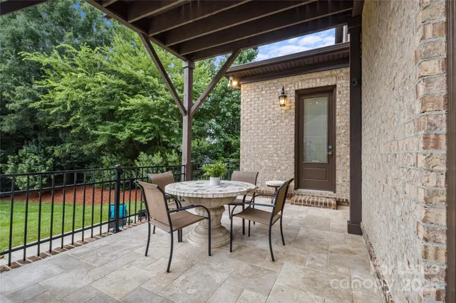 a view of a patio with table and chairs and floor to ceiling window
