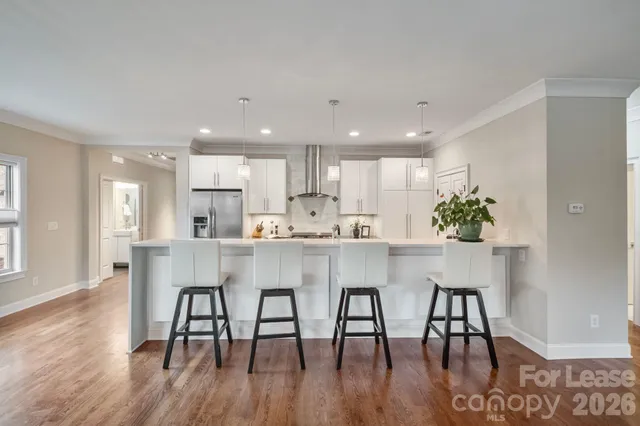 a spacious en suite bathroom with a double vanity sink a large mirror and a shower