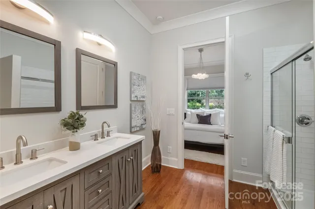 a bathroom with a double vanity sink a mirror and a shower