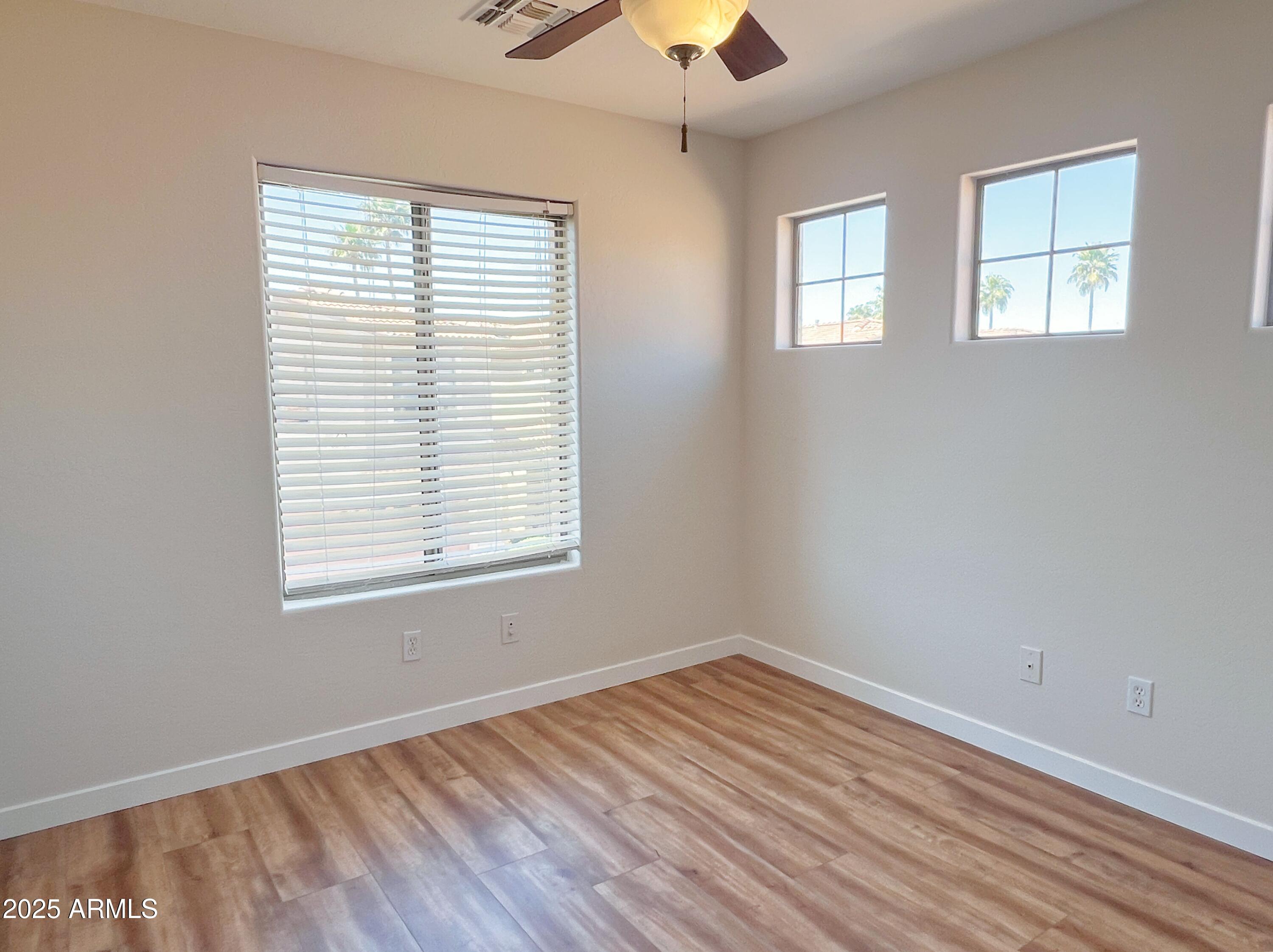 5415 East McKellips Road, Unit 90 Mesa, AZ 85215 - Photo 12 of 16 a view of an empty room with wooden floor and a window