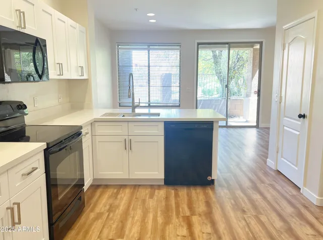 a kitchen with a sink stove and cabinets