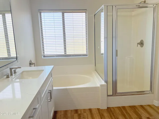 a bathroom with a tub sink and mirror