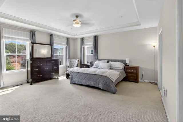 a spacious bedroom with a bed a fireplace and a large mirror