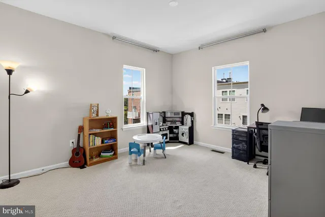 a view of a livingroom with workspace and a window