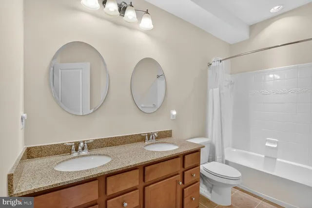 a bathroom with a granite countertop toilet a sink and a mirror