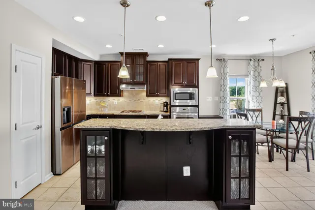 a kitchen with stainless steel appliances granite countertop a refrigerator a sink and a stove