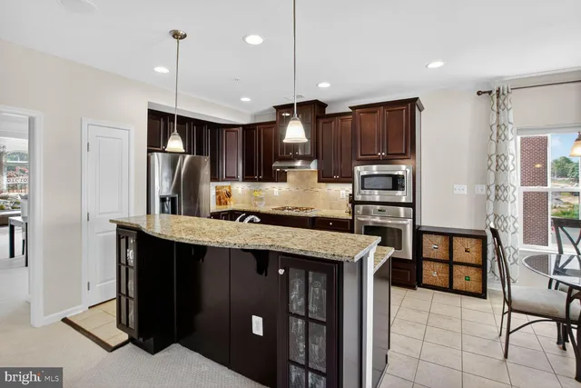 a kitchen with stainless steel appliances granite countertop a refrigerator a stove a sink and a refrigerator