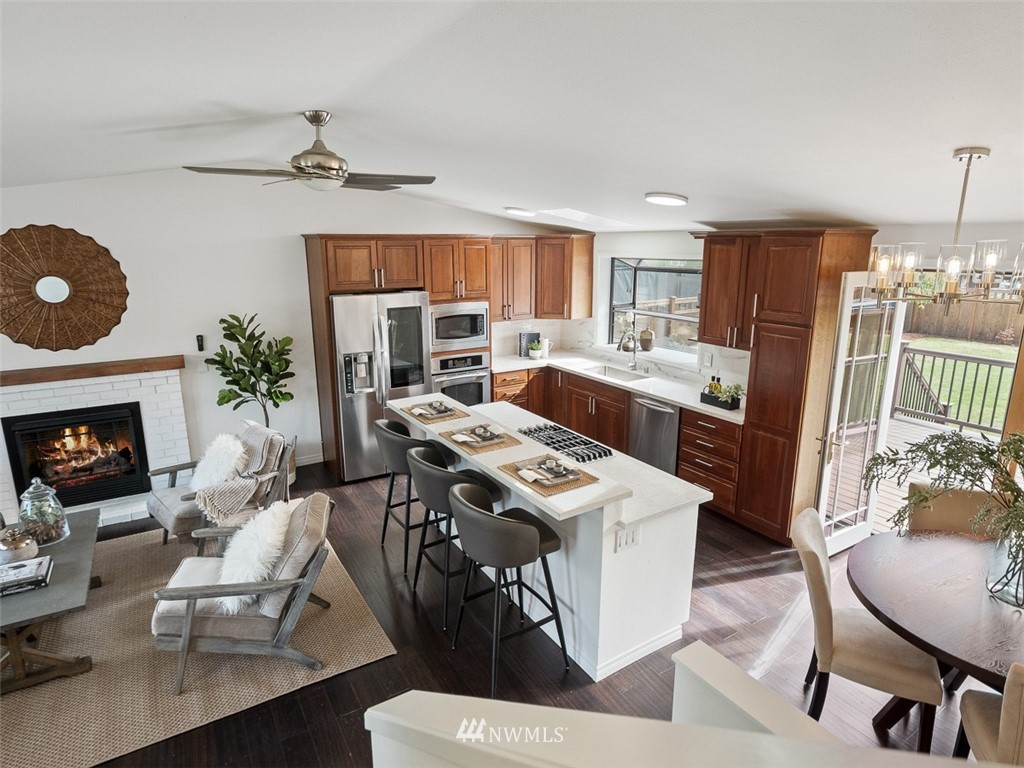18 199th Place Southeast Bothell, WA 98012 - Photo 18 of 23 a kitchen with stainless steel appliances a stove a refrigerator a microwave a dining table and chairs with wooden floor