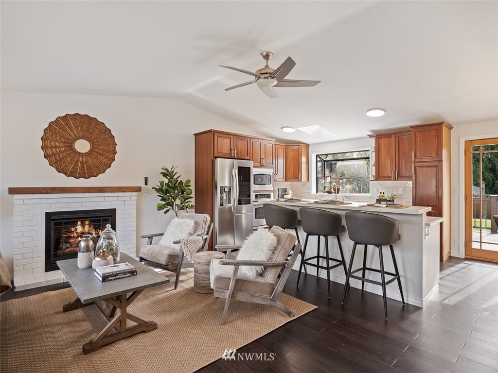 18 199th Place Southeast Bothell, WA 98012 - Photo 4 of 23 a living room with furniture a fireplace and kitchen view