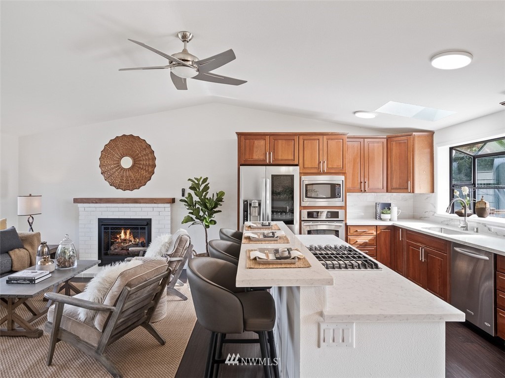 18 199th Place Southeast Bothell, WA 98012 - Photo 8 of 23 a living room with furniture a fireplace and kitchen view