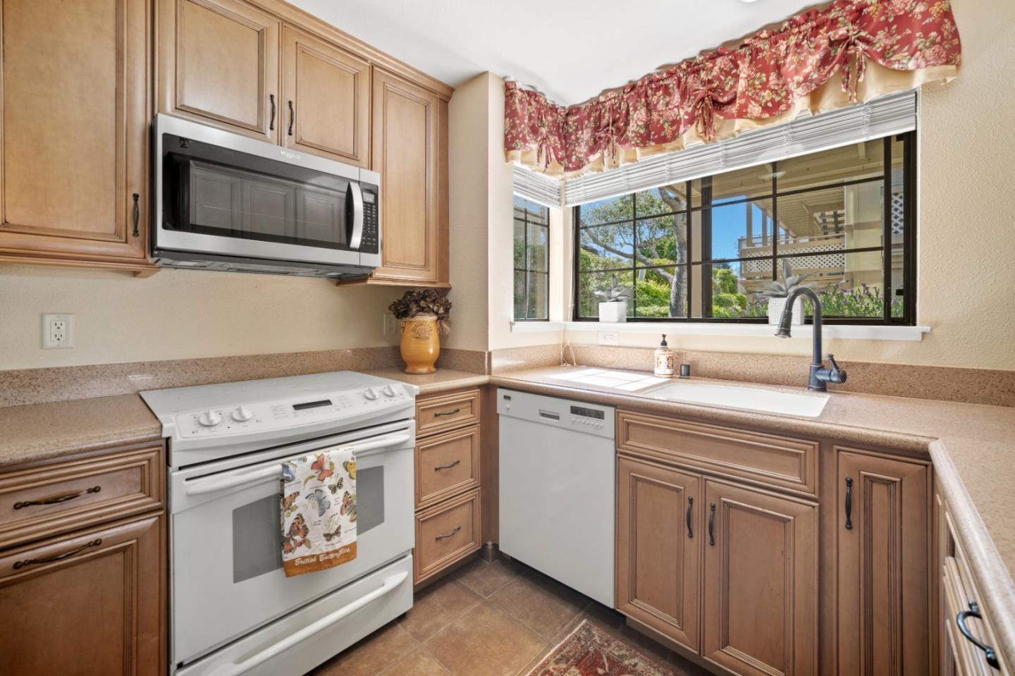 a kitchen with stainless steel appliances granite countertop a sink a stove and a microwave