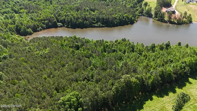 an aerial view of a house with a yard and lake view
