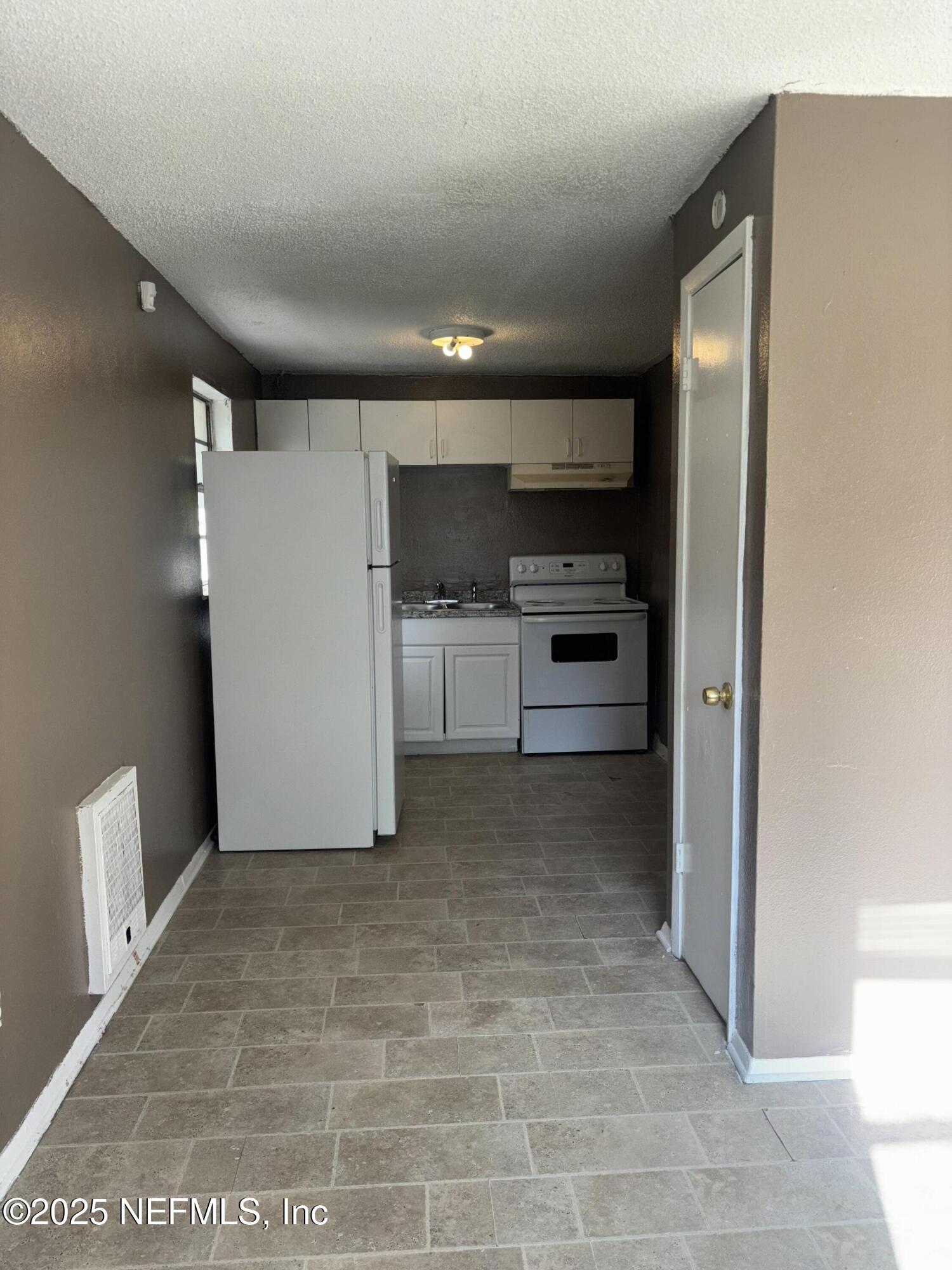 1115 Rushing Street Jacksonville, FL 32209 - Photo 7 of 24 a view of a kitchen with a sink and an empty room