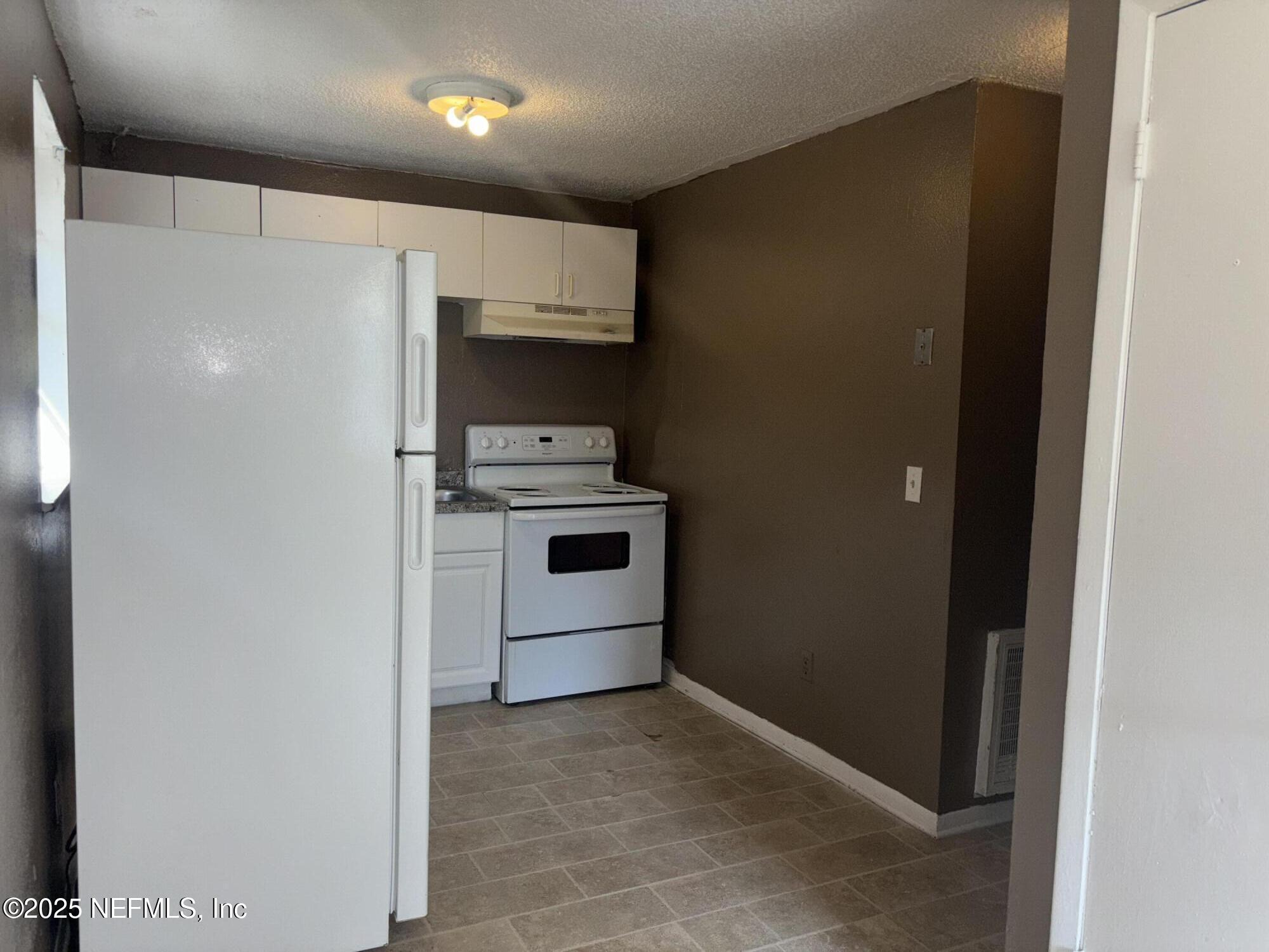 1115 Rushing Street Jacksonville, FL 32209 - Photo 8 of 24 a kitchen with stainless steel appliances a refrigerator and a stove