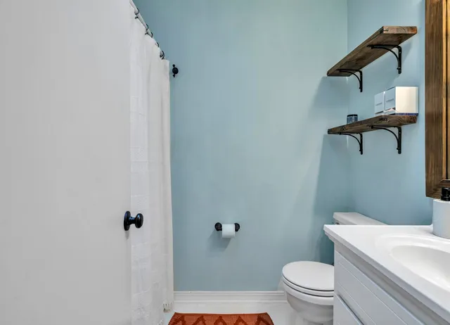 a white toilet sitting next to a shower