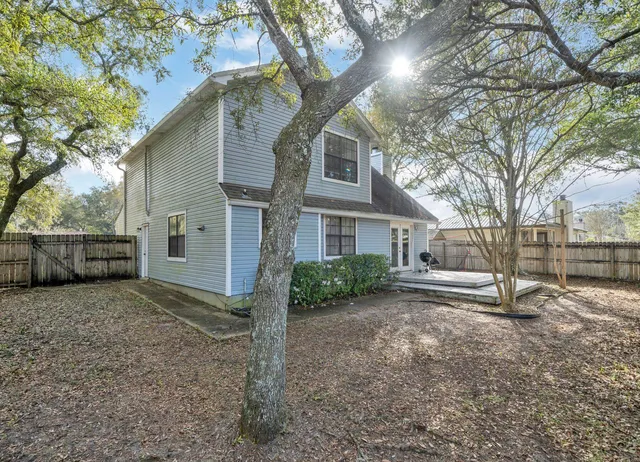 a view of a house with a yard and tree
