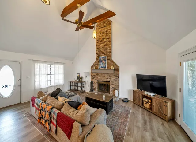 a living room with furniture a flat screen tv and a fireplace