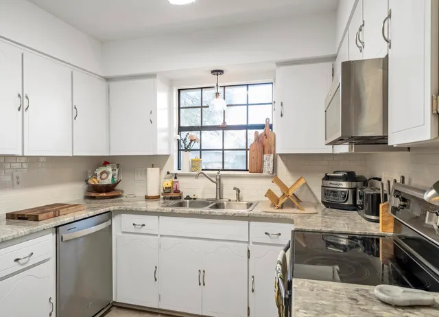 a kitchen with a sink stove top oven and cabinets