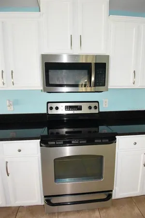 a stove top oven sitting inside of a kitchen