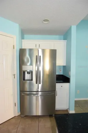a metallic refrigerator freezer sitting in a kitchen