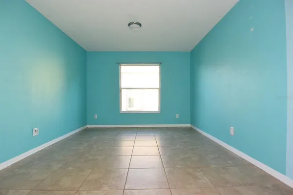 a view of an empty room with closet and a window