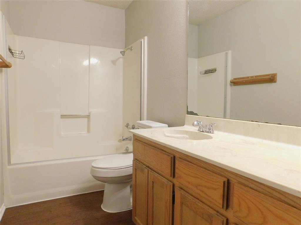 2214 Bernard Street Denton, TX 76205 - Photo 12 of 16 a bathroom with a granite countertop sink toilet and shower