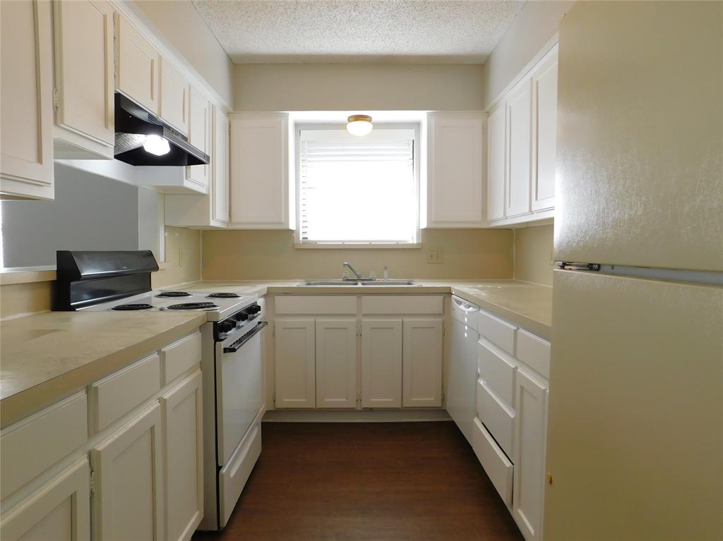 2214 Bernard Street Denton, TX 76205 - Photo 6 of 16 a kitchen with stainless steel appliances a white stove top oven a sink a window and white cabinets