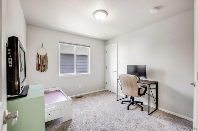 a livingroom with workspace and a window